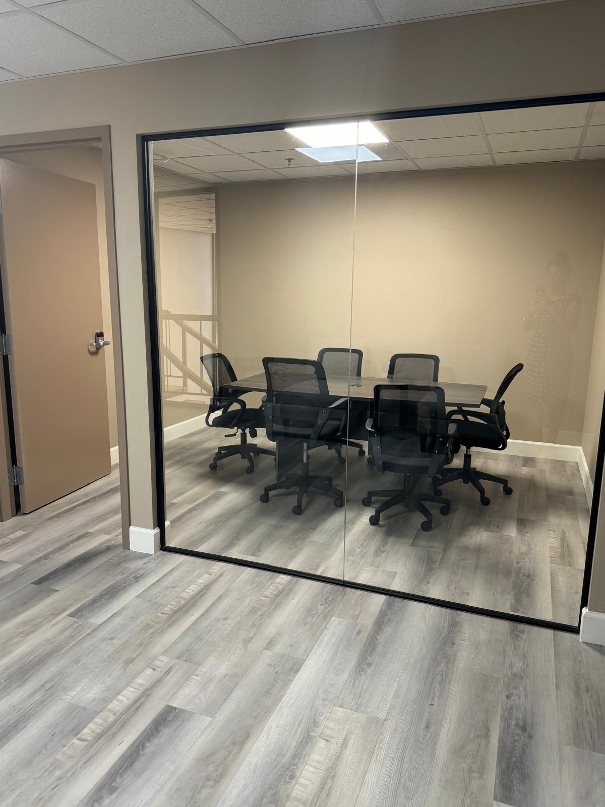 Our glass-fronted conference room with a meeting table and chairs